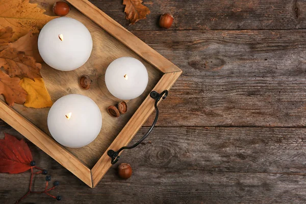 Bandeja con velas encendidas y hojas otoñales sobre fondo de madera —  Fotos de Stock