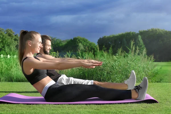 Joven pareja deportiva haciendo ejercicio en parque verde — Foto de Stock