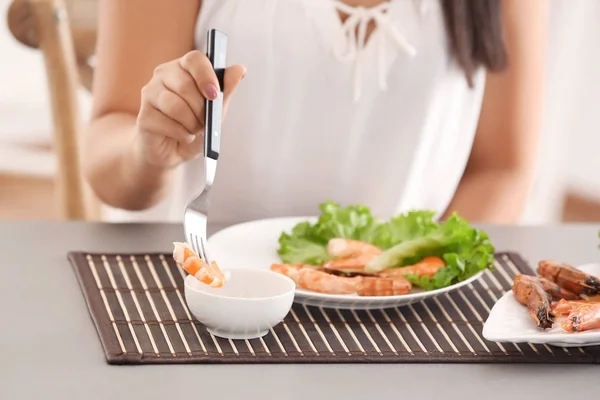 Mujer joven comiendo camarones en la mesa —  Fotos de Stock