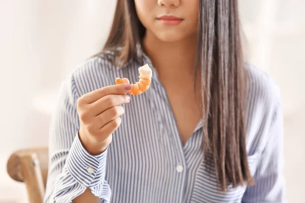 Beautiful woman eating shrimp, indoors — Stock Photo, Image