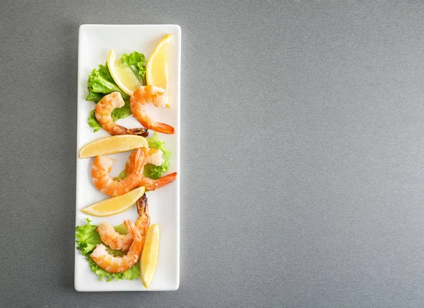 Marul ve limon ile lezzetli karides masaya servis