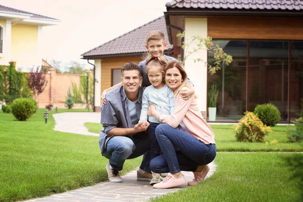 Lycklig familj på innergården nära deras hus — Stockfoto