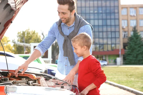 Aranyos fiú javítás autó, szabadban fiatal apa — Stock Fotó