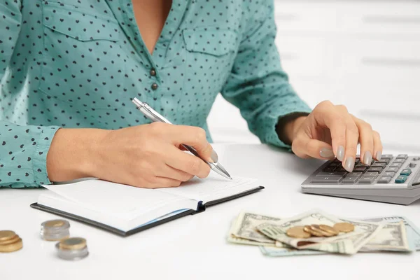 Жінка рахує податки за столом, крупним планом — стокове фото