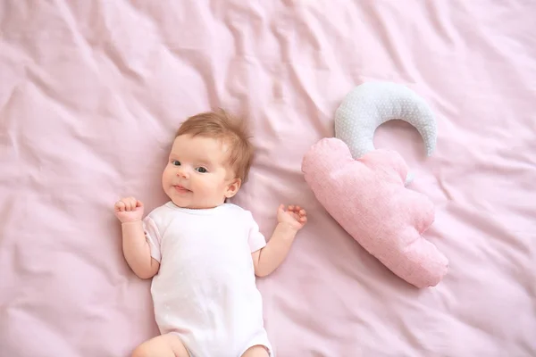 Bebê bonito e brinquedos na cama em casa — Fotografia de Stock