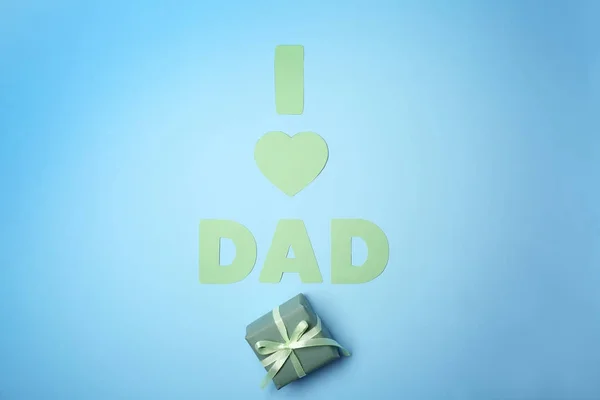 Composition with phrase I LOVE DAD and gift for Father's Day on color background — Stock Photo, Image