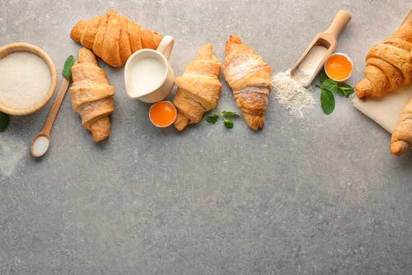 Composição com saborosos croissants e ingredientes sobre fundo cinza — Fotografia de Stock