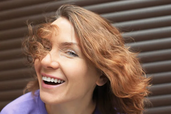 Hermosa mujer sonriente cerca de la pared de color —  Fotos de Stock