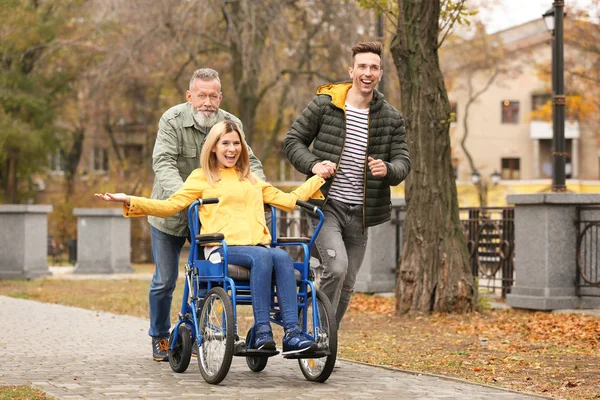 Šťastná žena na invalidním vozíku s rodinou venku na podzimní den — Stock fotografie