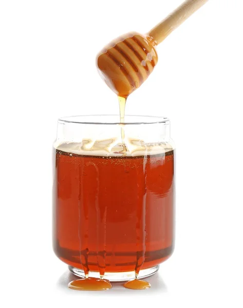 蜂蜜从酒壶里滴在白色的背景上 — 图库照片