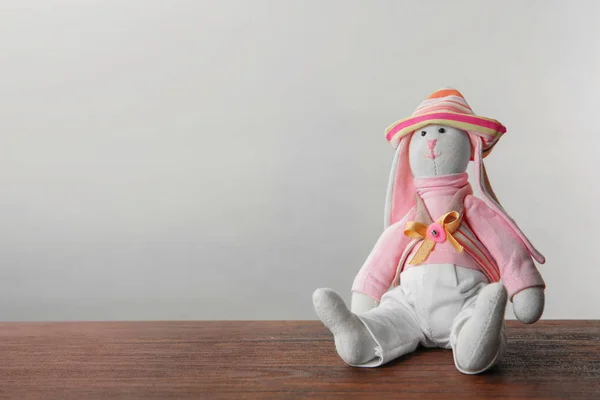 Carino giocattolo coniglietto su tavolo contro luce sfondo — Foto Stock