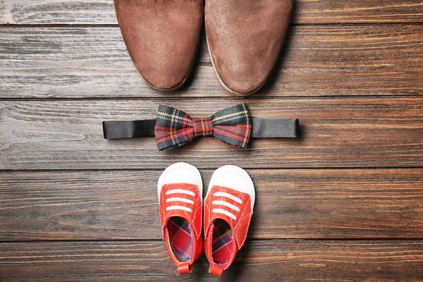 蝶ネクタイ、木製の背景に大小の靴。父の日の組成 — ストック写真