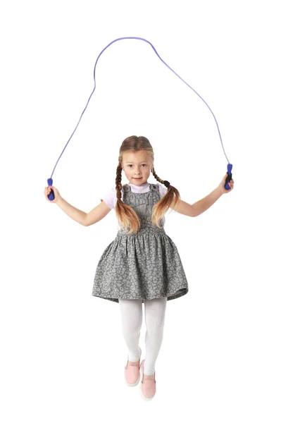 Симпатична маленька дівчинка грає зі стрибком мотузки на білому тлі — стокове фото