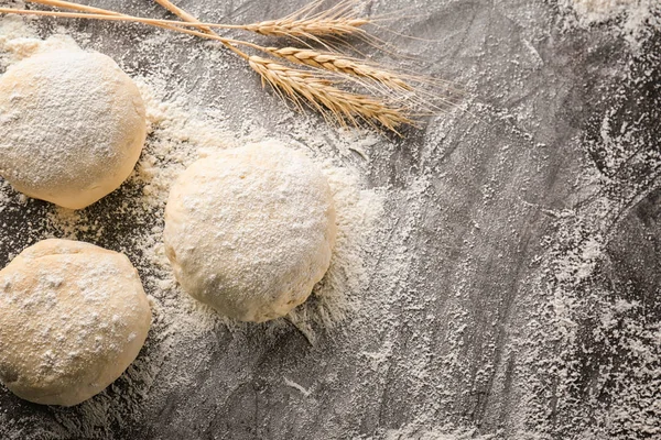 Raw dough balls with flour on table