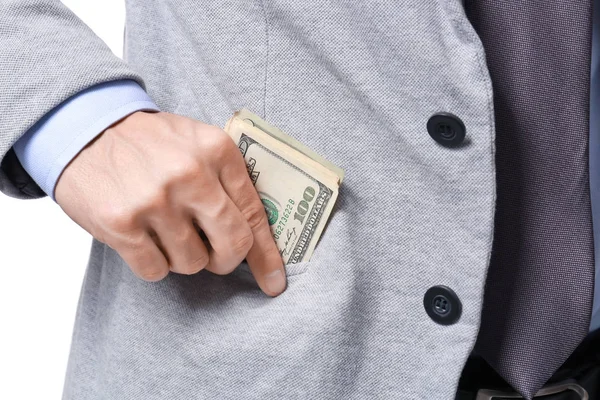 Homem em terno formal colocando dinheiro no bolso no fundo branco, close-up — Fotografia de Stock