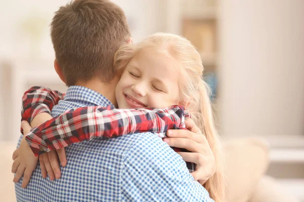 Linda niña abrazando a su padre en casa —  Fotos de Stock