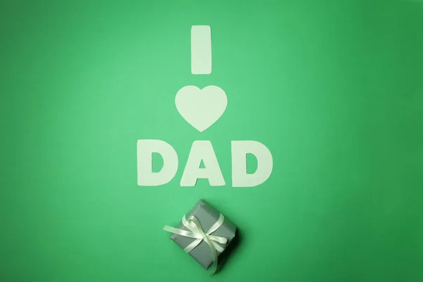Composición con frase I LOVE DAD y regalo para el Día del Padre sobre fondo de color — Foto de Stock