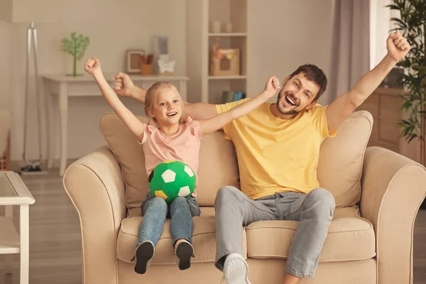 Cute girl i jej ojciec oglądając mecz piłki nożnej w telewizji — Zdjęcie stockowe