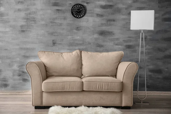 Stylish sofa with lamp near wall indoors — Stock Photo, Image