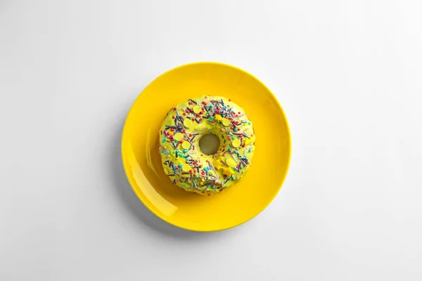 Yellow plate with tasty donut on white background — Stock Photo, Image