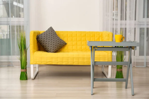 Стильный диван и небольшой стол в интерьере гостиной — стоковое фото