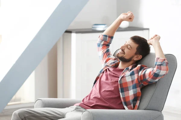 Hombre guapo relajándose en sillón en casa — Foto de Stock