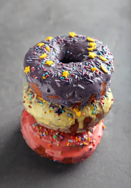 Bunte Donuts mit Streusel auf grauem Hintergrund — Stockfoto