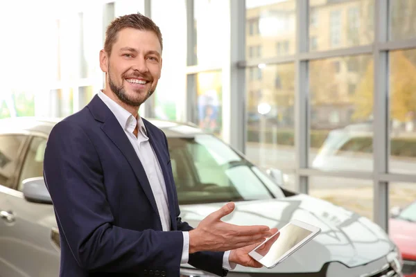 Bellissimo venditore di auto con tablet nel centro di distribuzione — Foto Stock