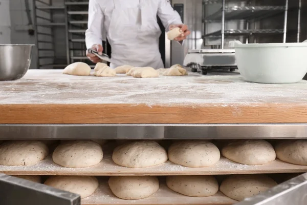 Brot in den Regalen und Mann in der Bäckerei — Stockfoto