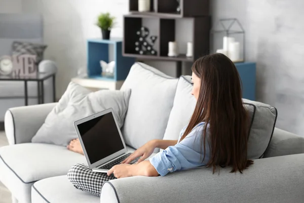 Fiatal nő laptop kanapén otthon — Stock Fotó