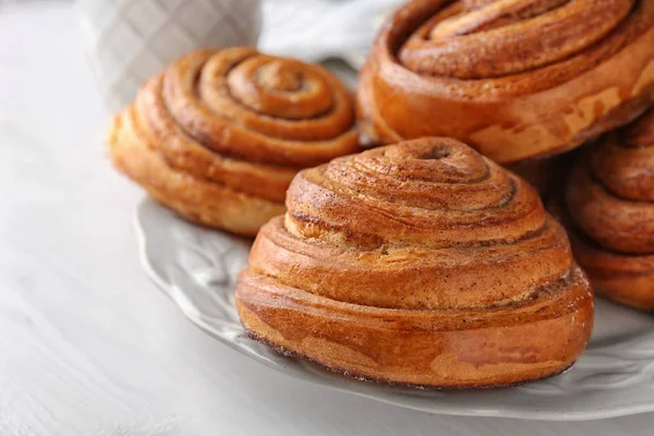 Plate with sweet cinnamon rolls on table — Stock Photo, Image