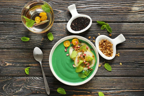 Schüssel mit grünem Spirulina-Smoothie auf dem Tisch. gesundes veganes Ernährungskonzept — Stockfoto