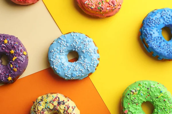 Donuts savoureux avec des aspersions sur fond de couleur — Photo