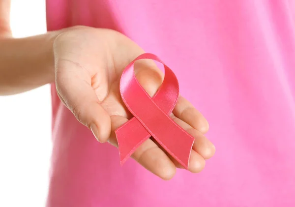 Mujer sosteniendo cinta rosa sobre fondo blanco. Concepto de conciencia sobre el cáncer de mama — Foto de Stock