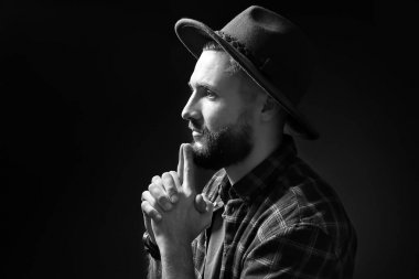 Siyah arka plan üzerine düşünceli genç hipster adam