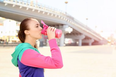 Genç kadın Protein içeceği açık havada içki