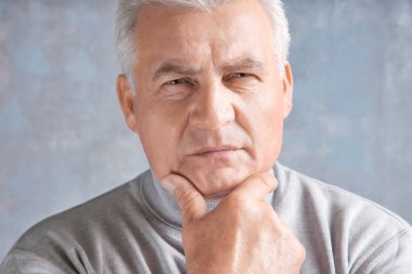 Gri arka plan üzerinde rahat kıyafetler içinde üst düzey yakışıklı