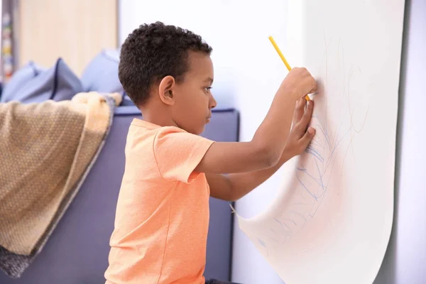 Kleine Afro-Amerikaanse jongen puttend uit papier roller binnenshuis — Stockfoto