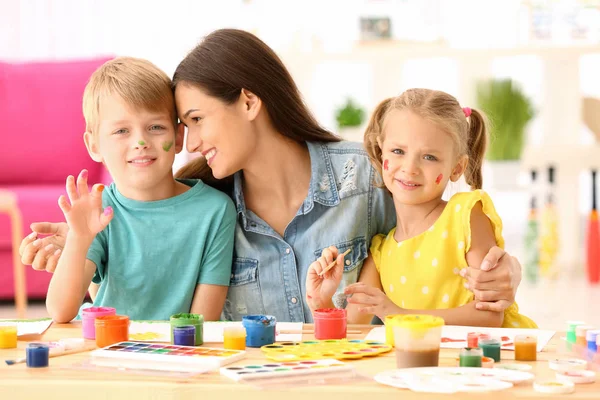 Gelukkige familie schilderij foto's aan tafel binnenshuis — Stockfoto