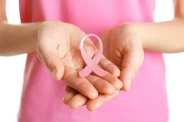 Mujer sosteniendo cinta rosa sobre fondo blanco. Concepto de conciencia sobre el cáncer de mama — Foto de Stock
