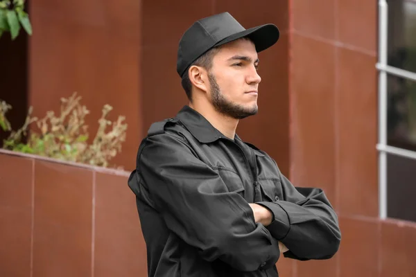 Male security guard near building outdoors — Stock Photo, Image