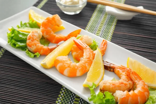 Delicious shrimps with lettuce and lemon on plate — Stock Photo, Image