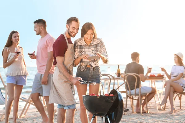 Jóvenes teniendo fiesta de barbacoa en la playa —  Fotos de Stock