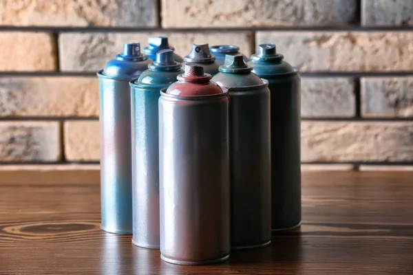 Used cans of spray paint near brick wall — Stock Photo, Image