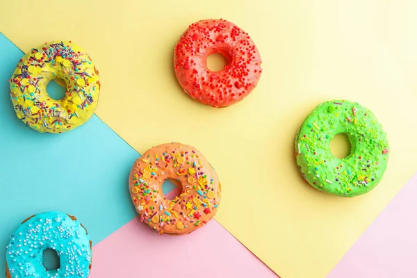 Tasty donuts with sprinkles on color background — Stock Photo, Image