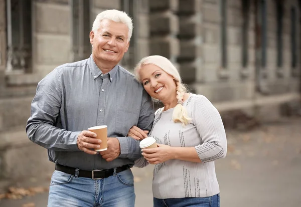 成熟的夫妇与杯咖啡一起走在户外 — 图库照片