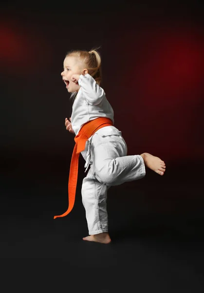 Küçük kız karate koyu arka plan üzerinde pratik — Stok fotoğraf