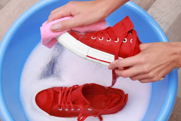 Vrouw wassen sneakers — Stockfoto