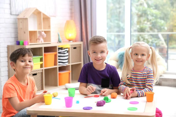 Niños pequeños dedicados al modelado de masa de juego en la guardería — Foto de Stock