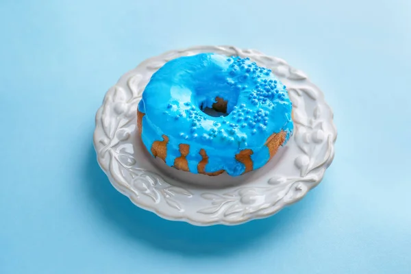 Assiette avec beigne bleu sur fond de couleur — Photo